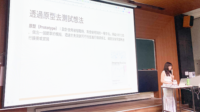 演講現場的側拍,講師正在分享「透過原型去測試想法」的投影片內容